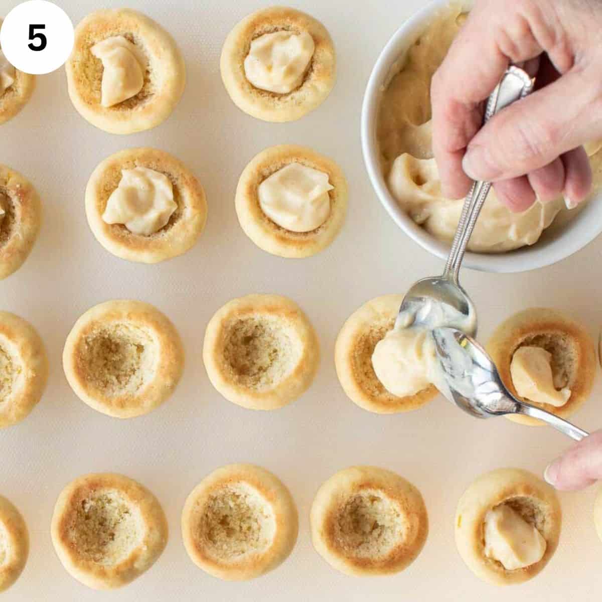 Filling hollowed out homed baked cookies with pastry cream.