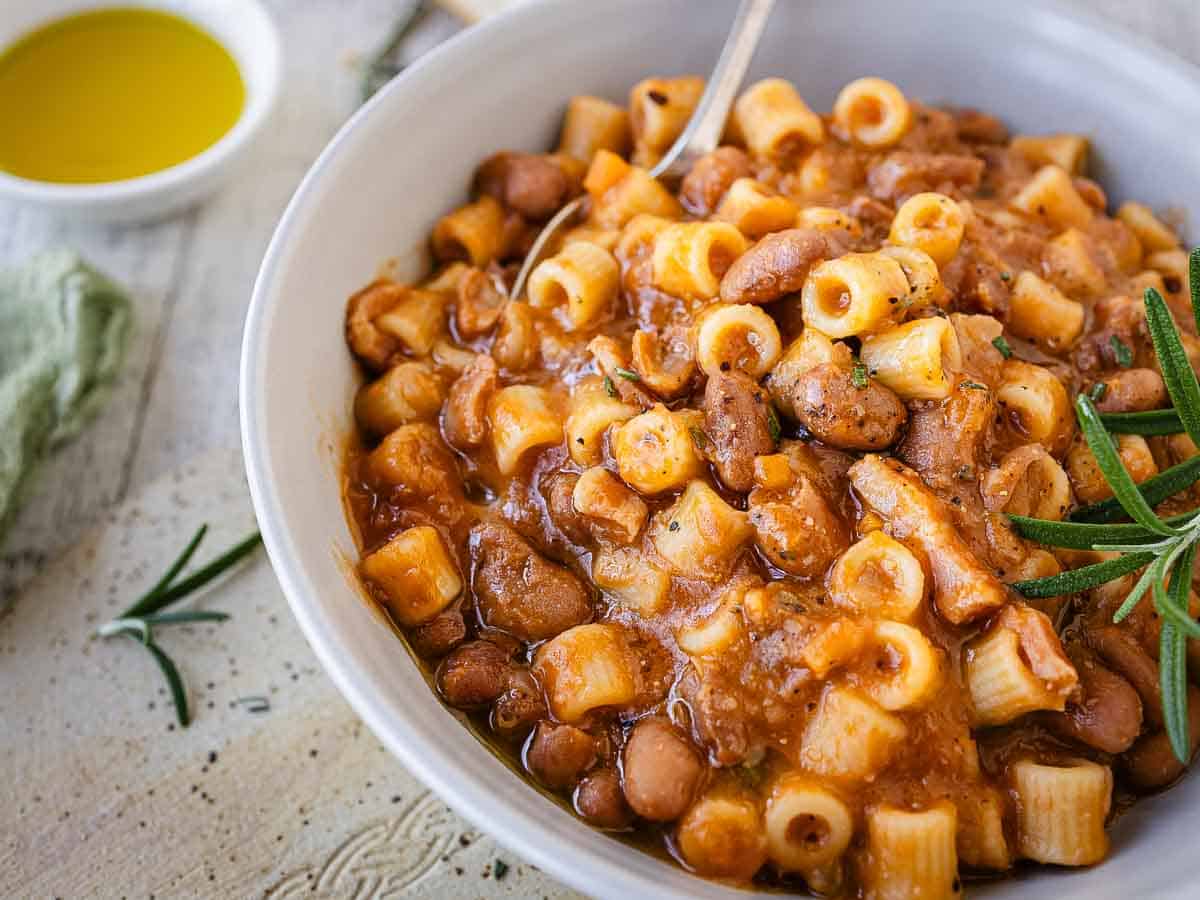 Close up of thick bean and pasta soup in a bowl.