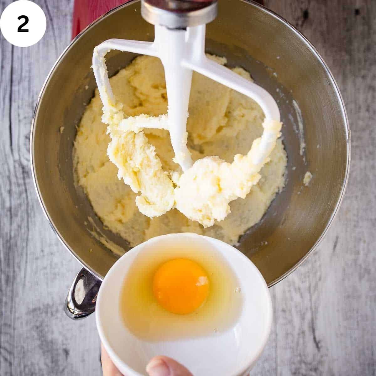 Adding an egg to creamed butter and sugar.