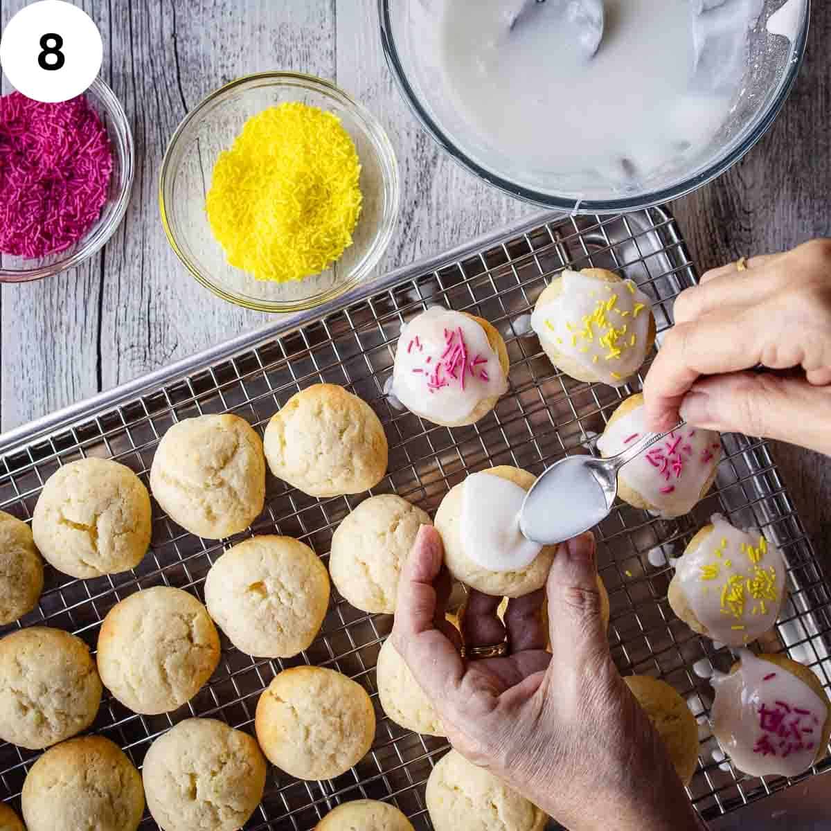 Spreading glaze onto baked cookies.