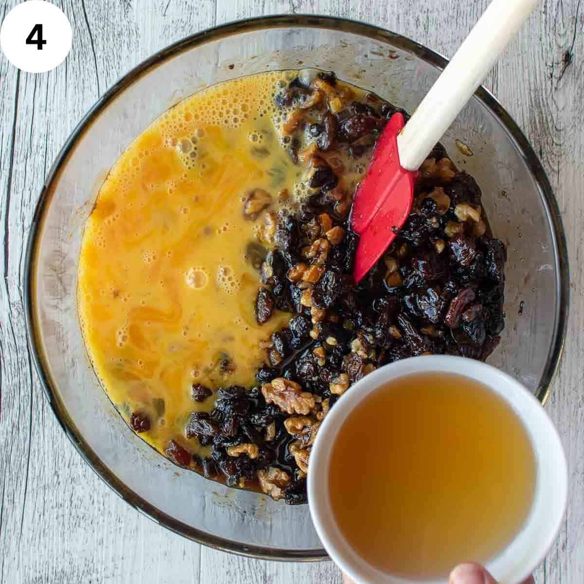 Beaten eggs and rum being stirred into soaked dried fruit for a fruit cake.