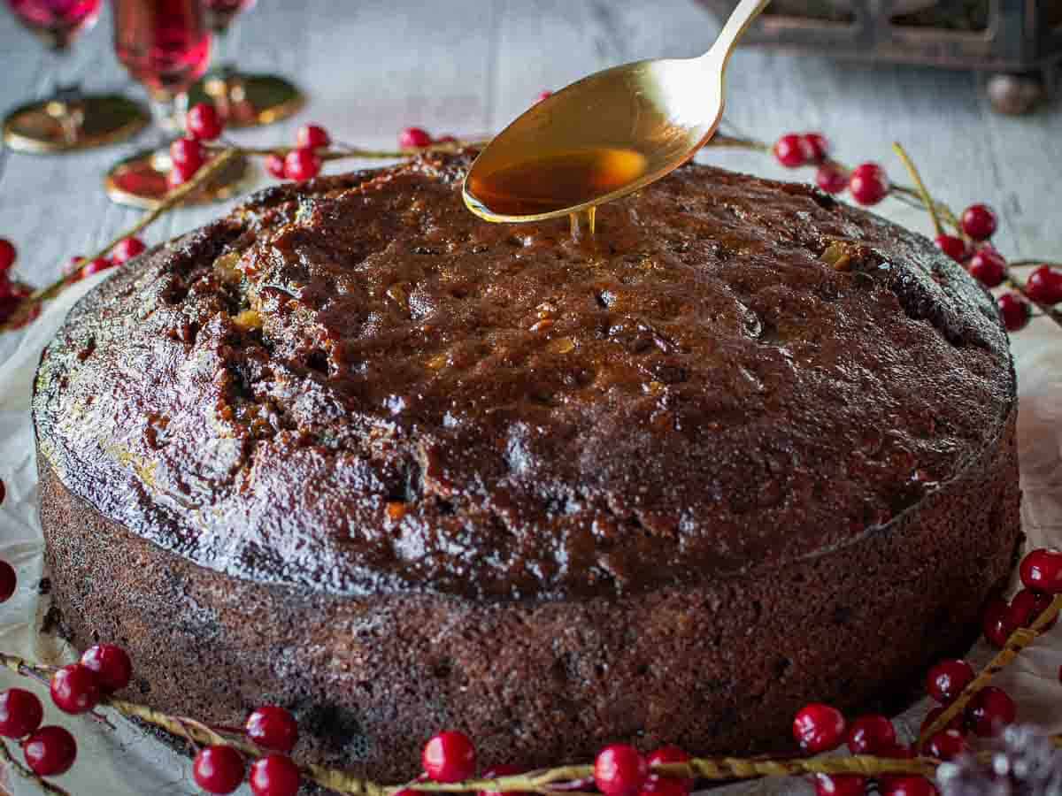 Pouring rum over a fruit cake.