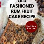 A round Rum Fruit Cake with a two slices cut and pulled out to show the inside of the cake.