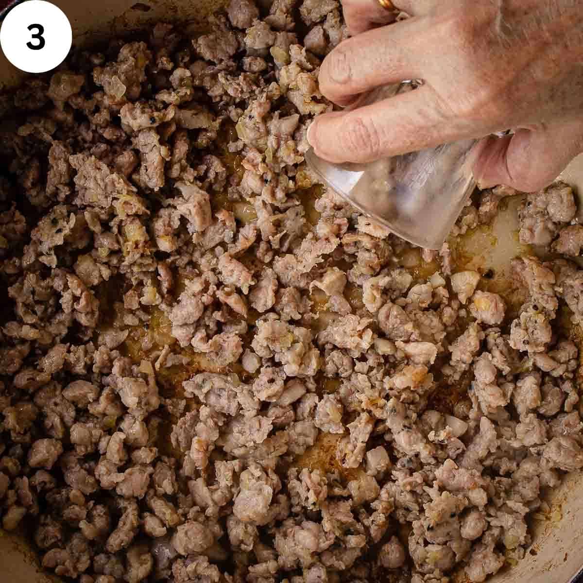 Pouring white wine into browned meat.