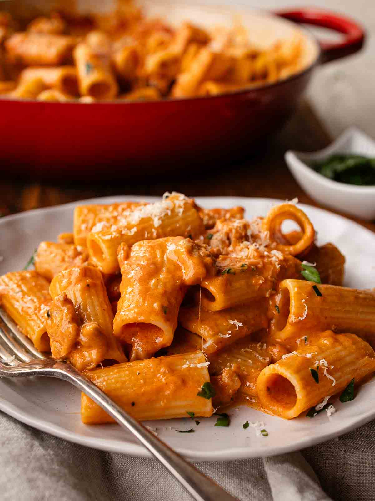 Creamy sausage pasta on a plate with a fork.