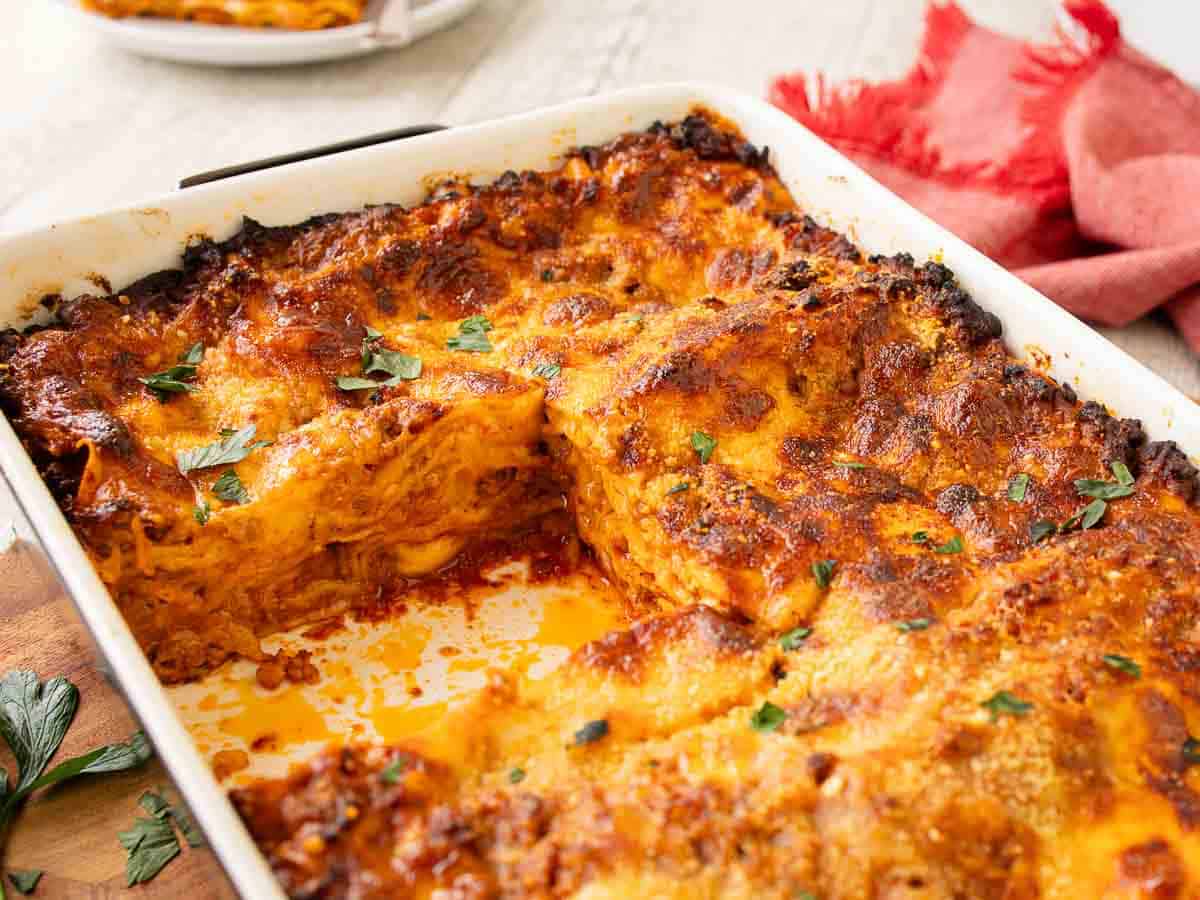 Close up of lasagna with a piece cut out.