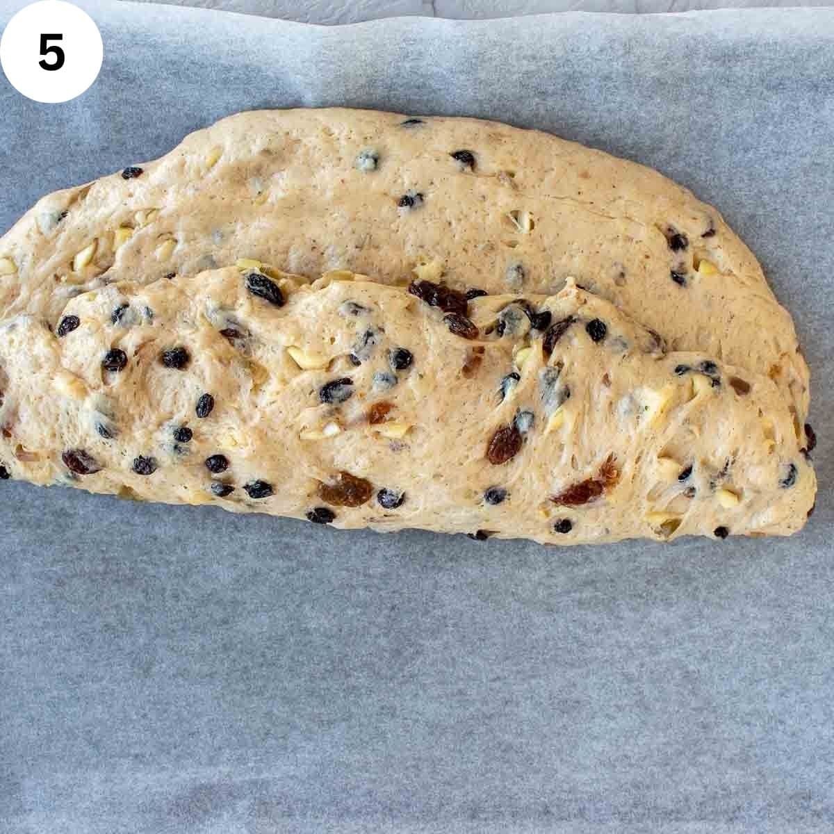 Dough with dried fruit through it folded over into a semicircle.