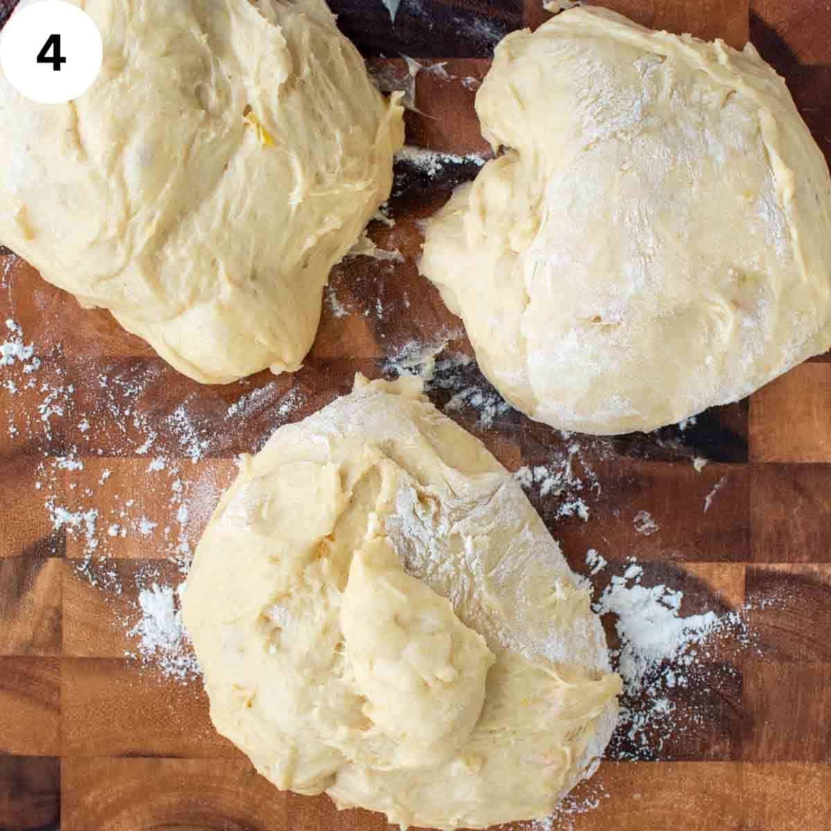 Three lumps of soft dough on a wooden board.