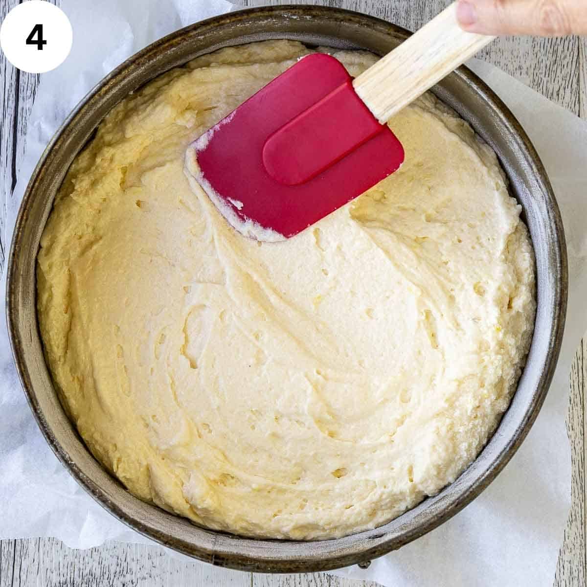 Cake batter being levelled in a cake pan.