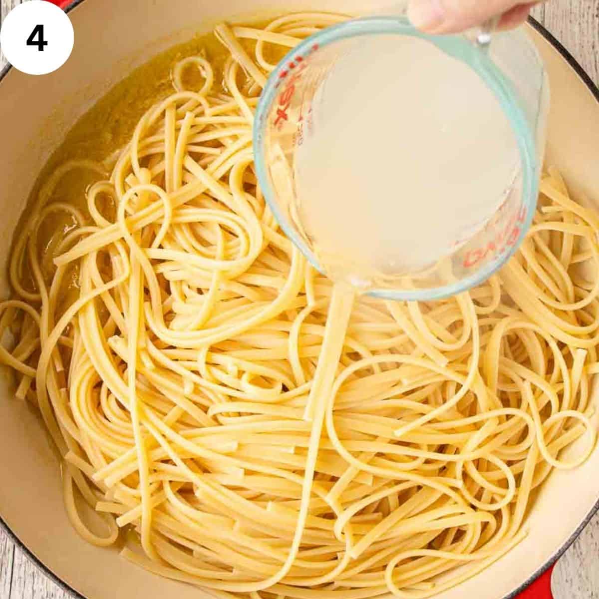 Adding starchy pasta water to a pan of cooked linguine pasta.