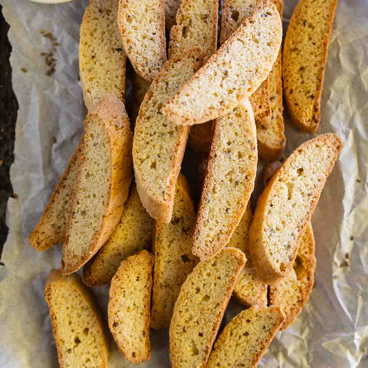 A pile of anise biscotti on parchment paper.