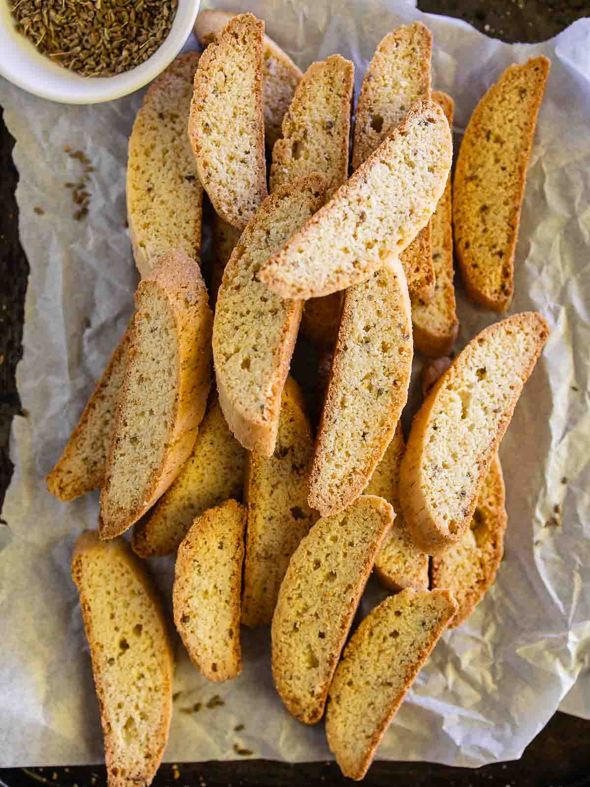 A pile of anise biscotti on parchment paper.