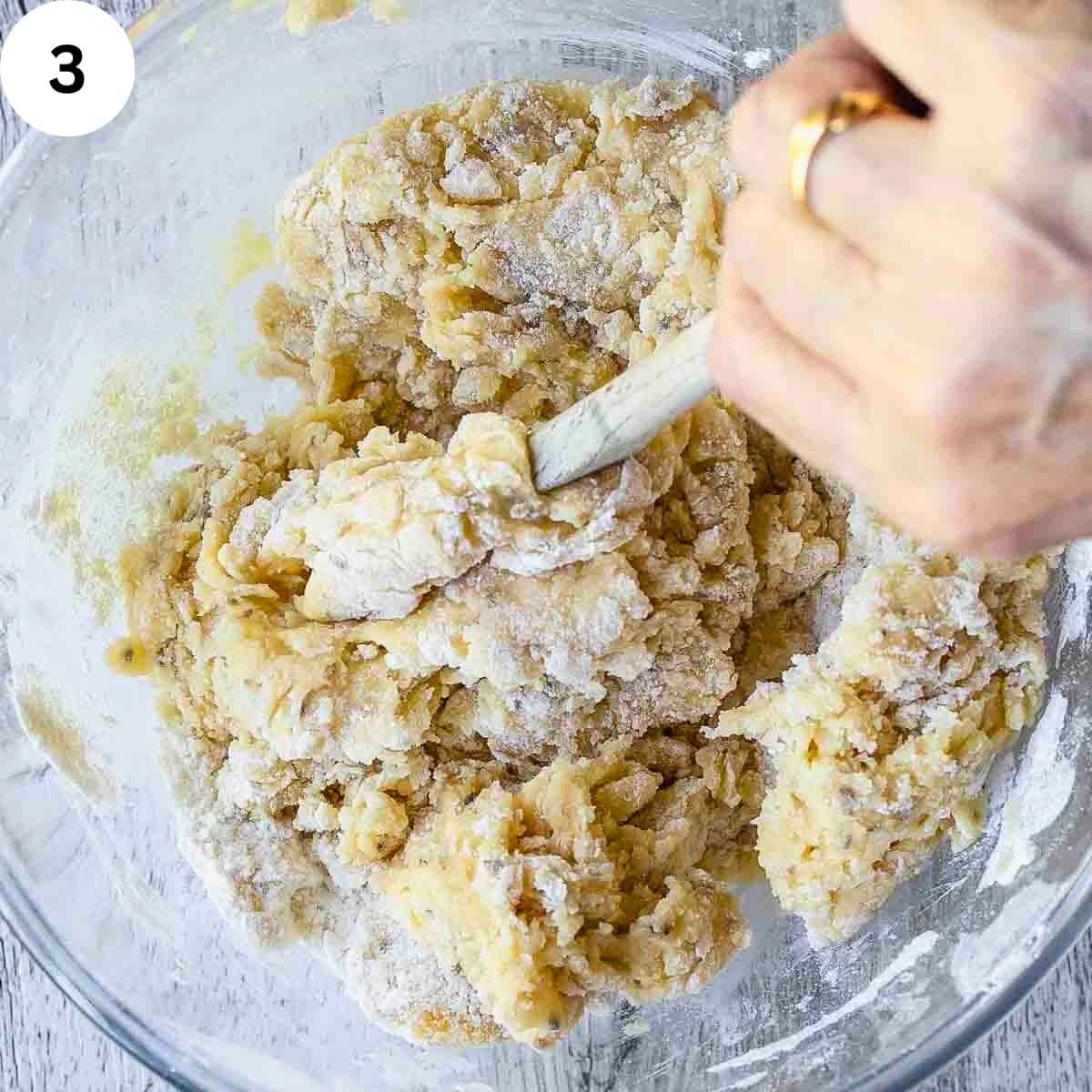 Using a wooden spoon to stir a thick dough.