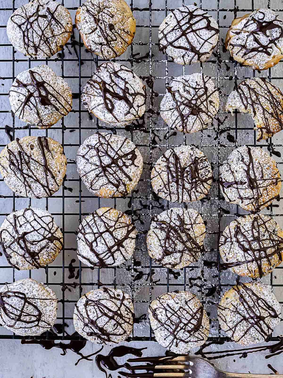 Chocolate drizzled cookies on a wire baking rack.