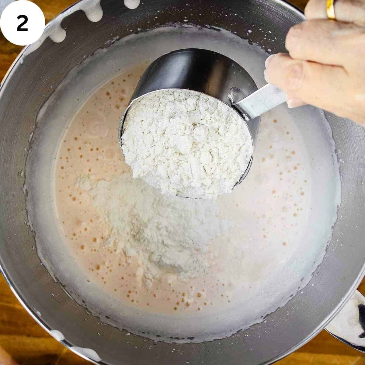 Tipping flour into whipped egg mixture.