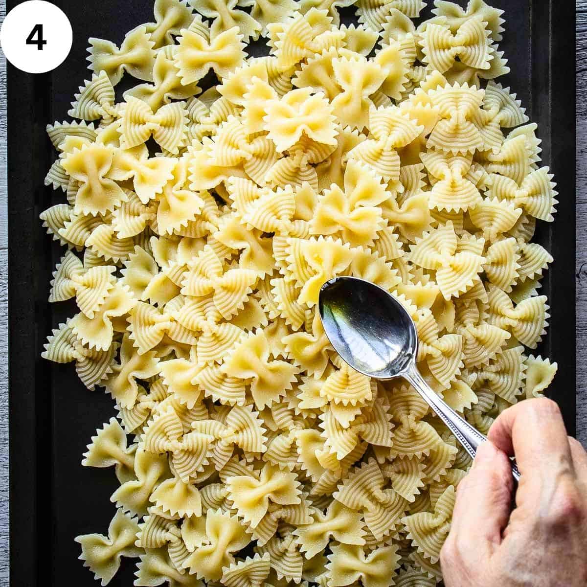 Drizzling oil over cooked pasta.