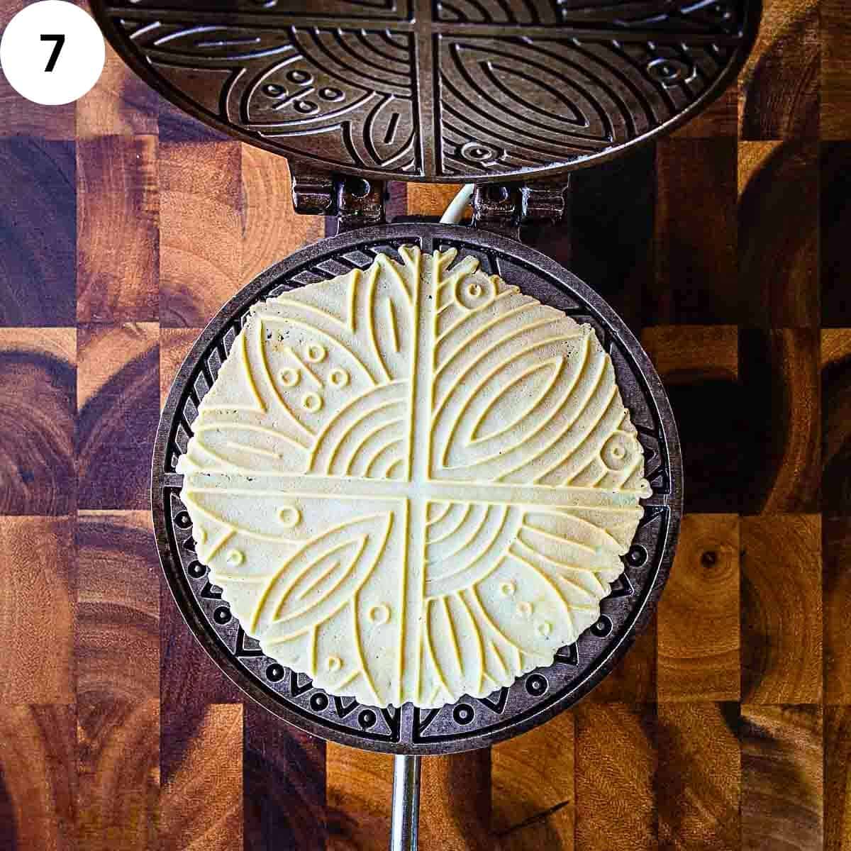 A patterned thin waffle in a waffle or pizzelle iron.