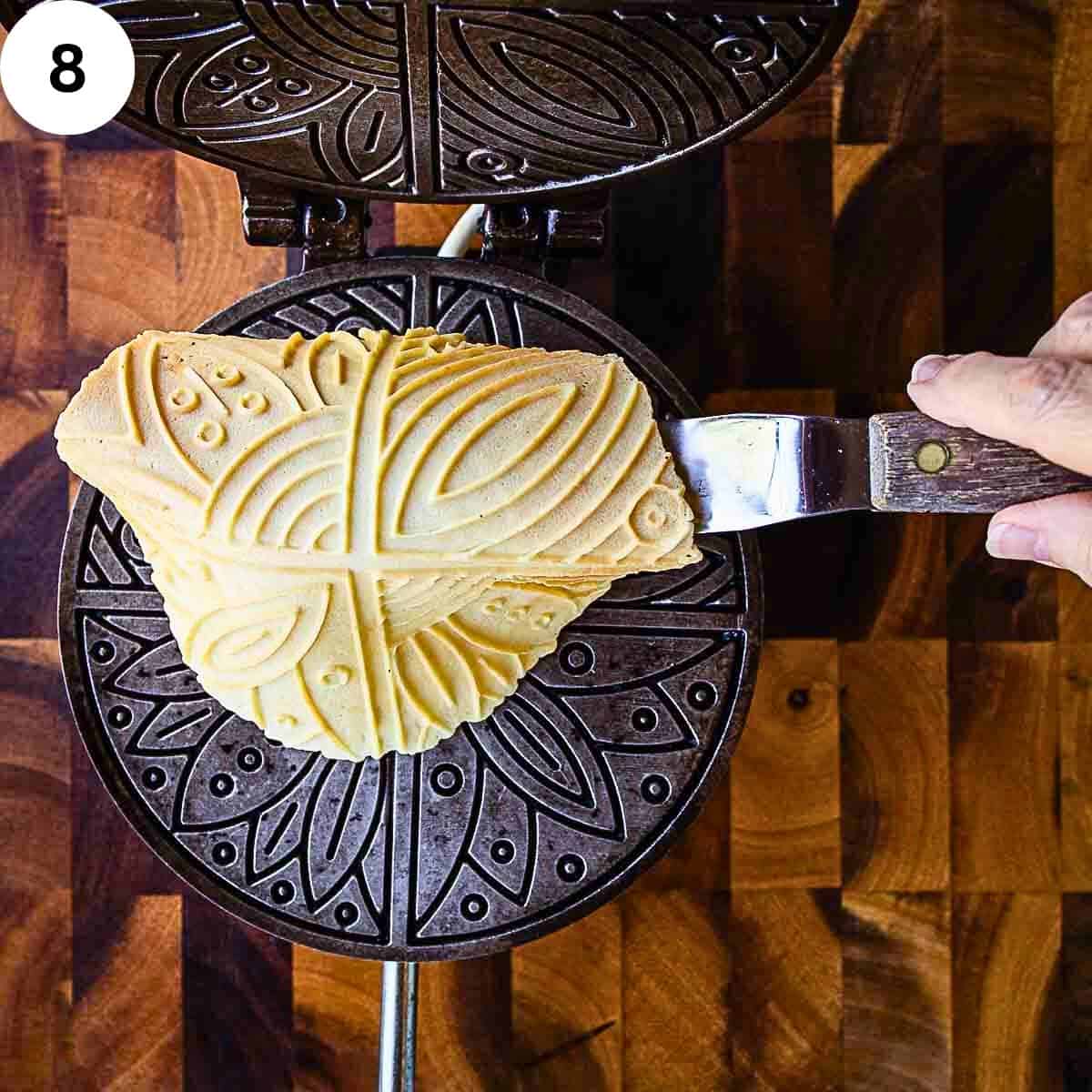 Lifting a soft pizzelle cookie from the iron.