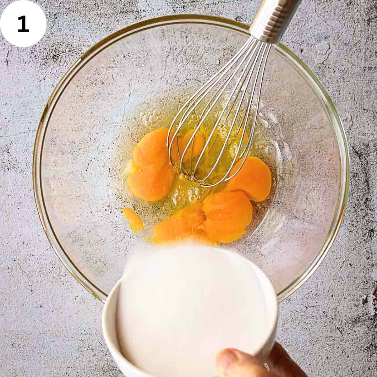 Adding sugar to eggs in a bowl.