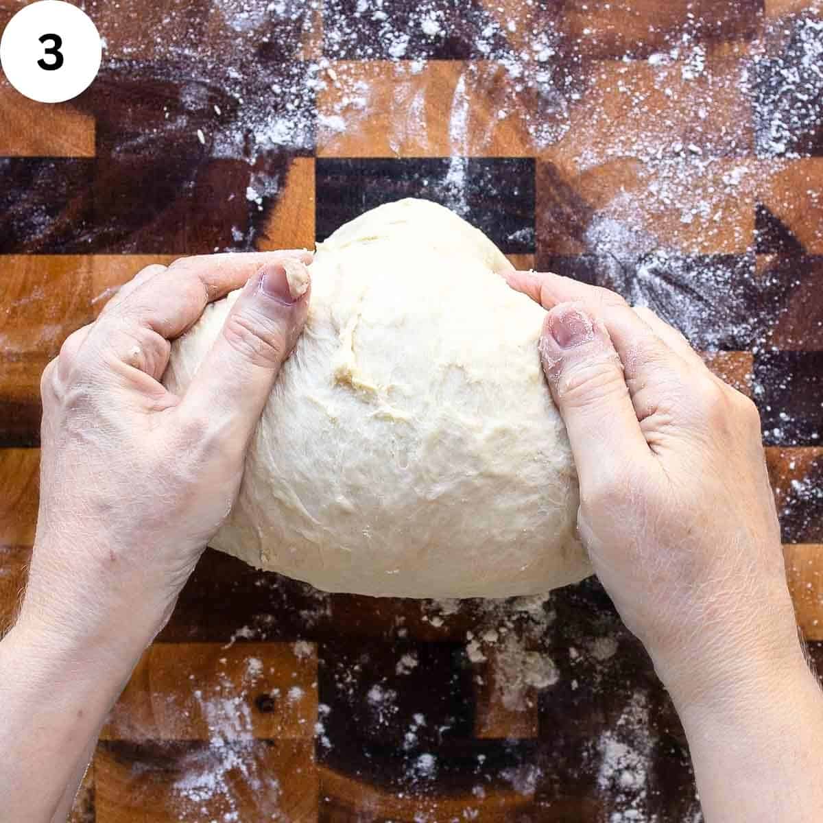 Shaping bread dough into a ball.