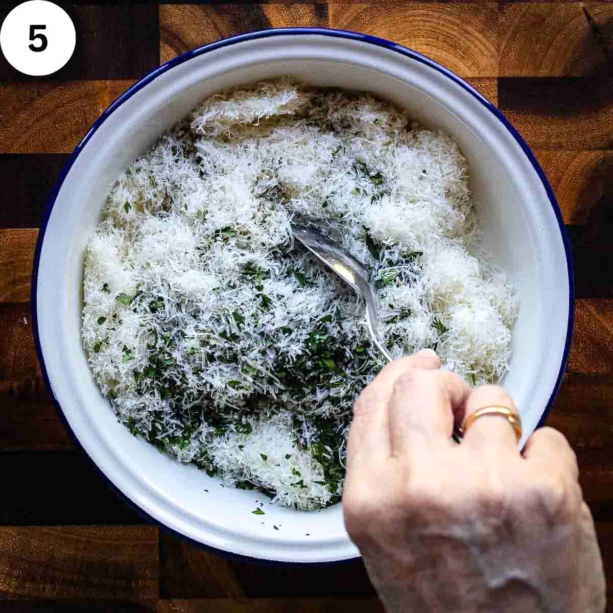 Mixing Parmesan cheese with herbs in a bowl.