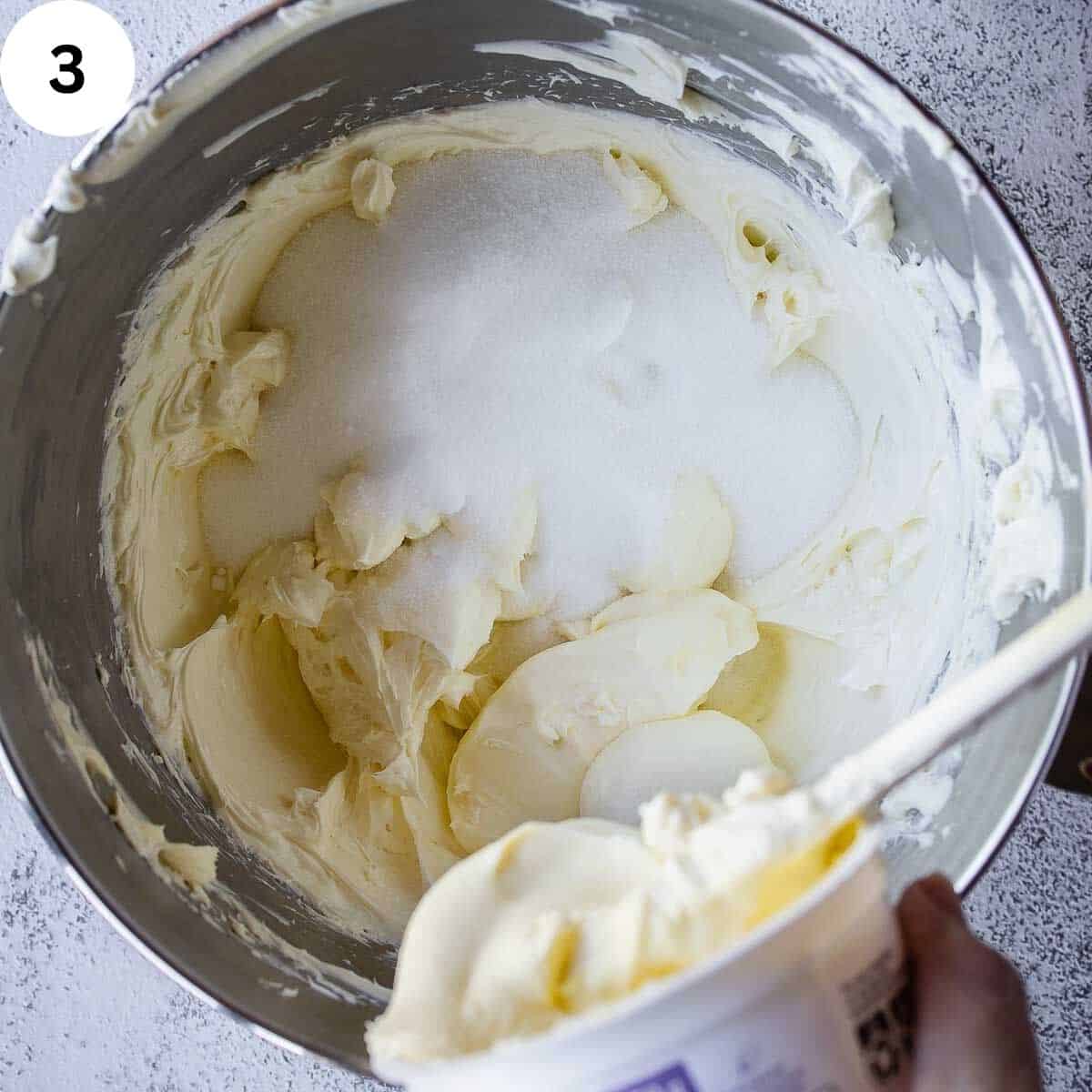 Adding mascarpone to bowl of cream cheese and sugar.