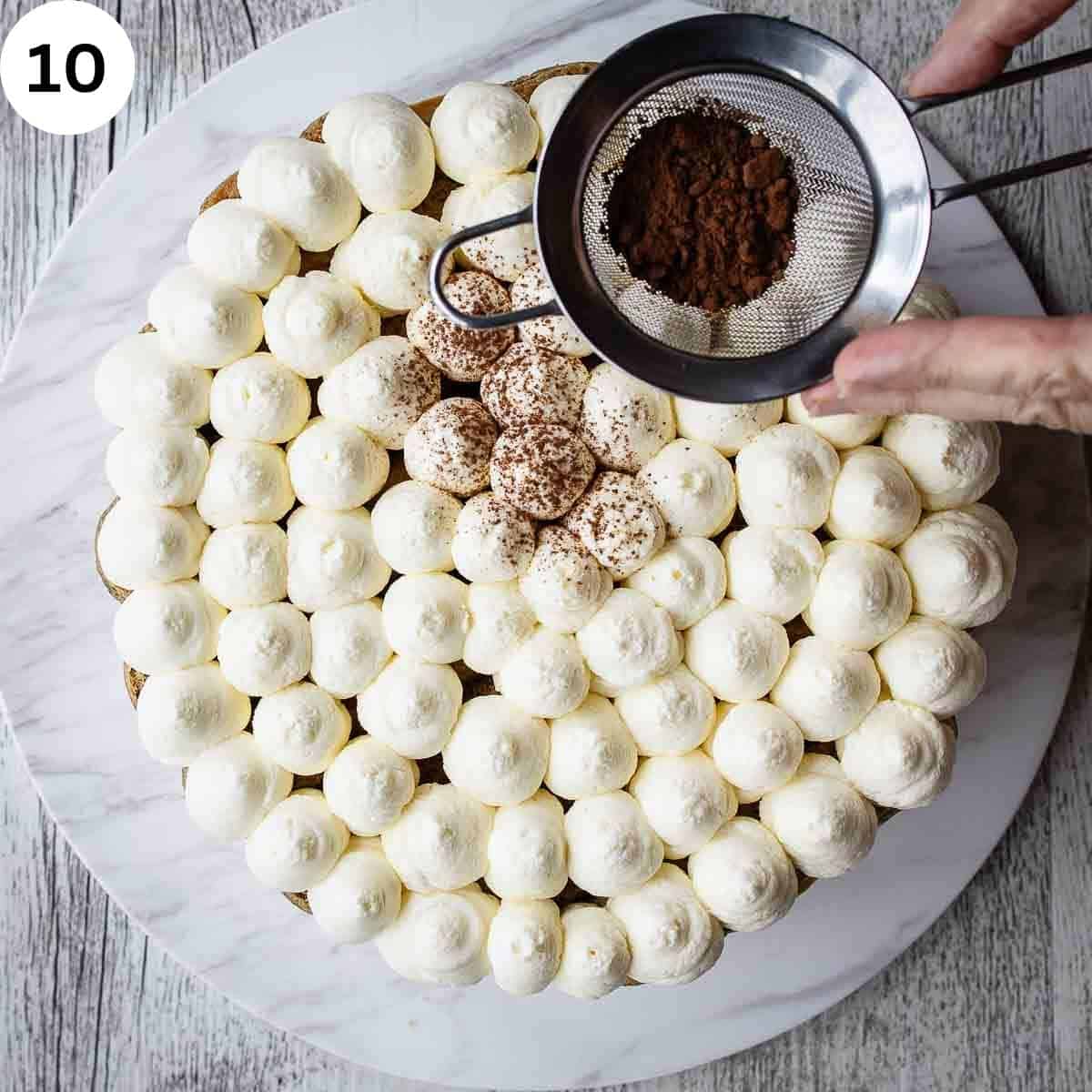 Sieving cocoa powder onto piped mounds of cream.