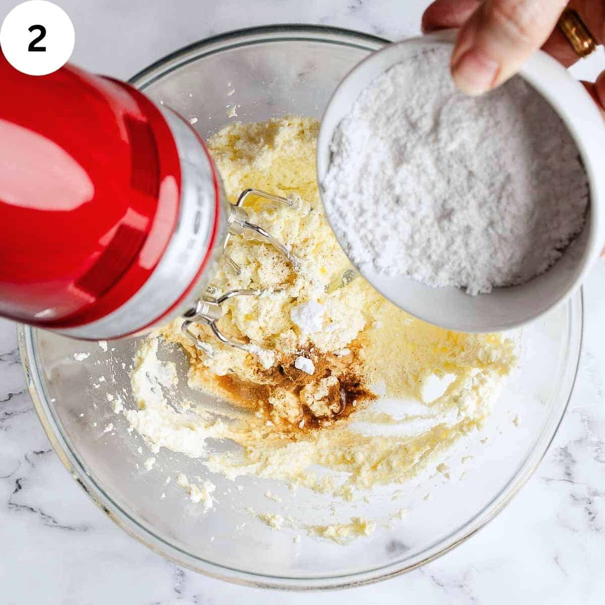 Adding powdered sugar and vanilla to whipped ricotta.