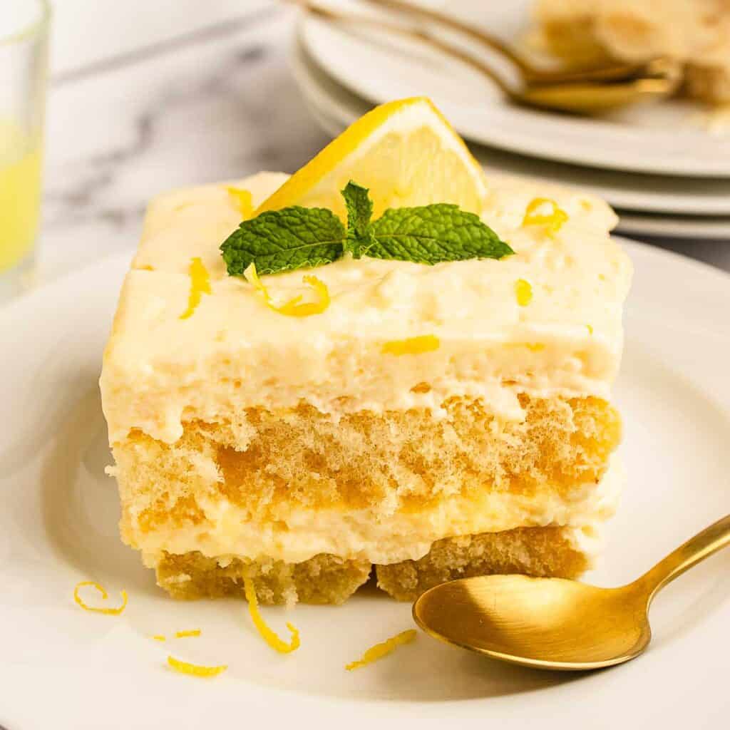 Square slice of Limoncello Tiramisu on a plate showing layers of savoiardi and cream filling.