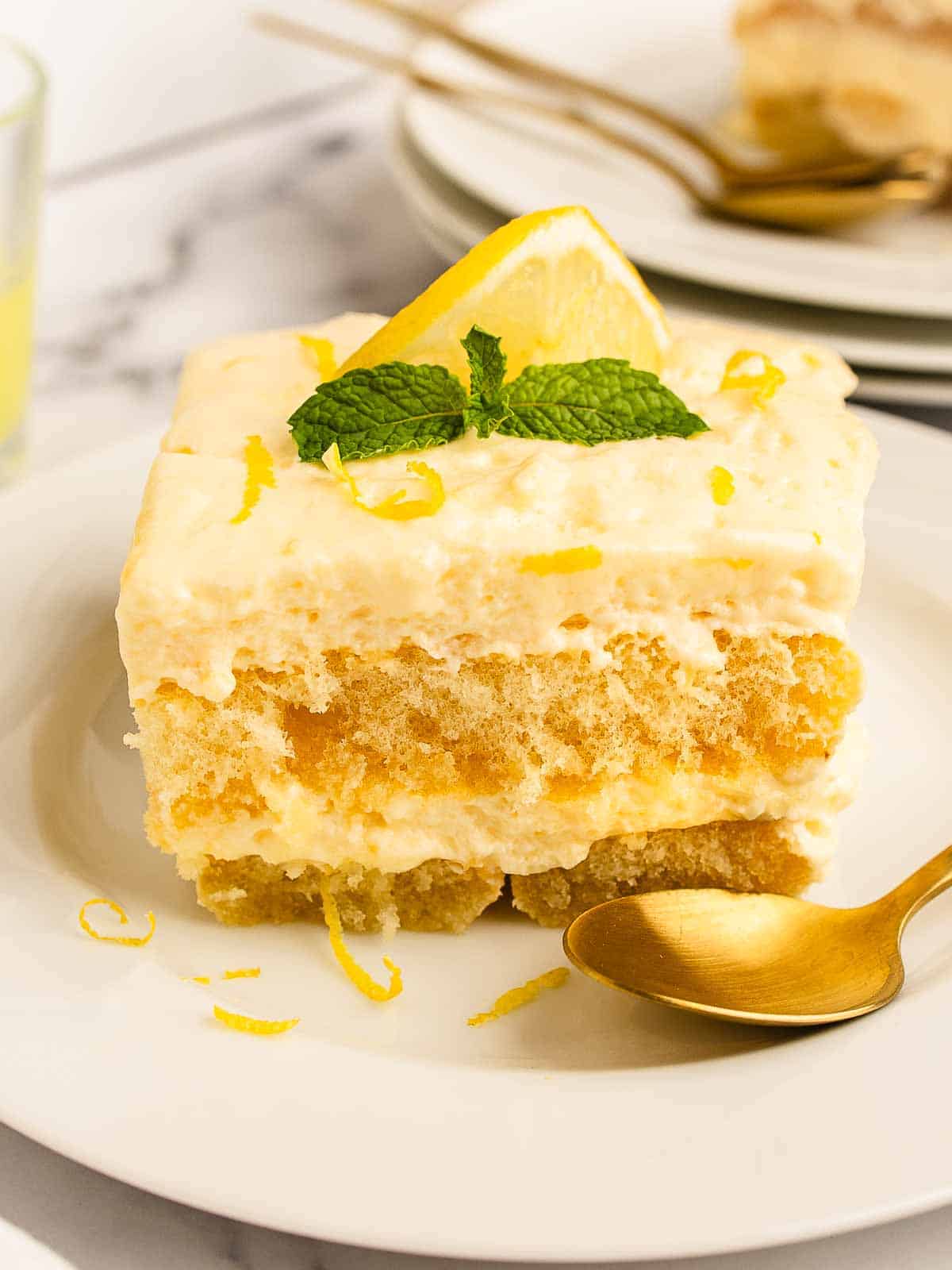 Square slice of Limoncello Tiramisu on a plate showing layers of savoiardi and cream filling.