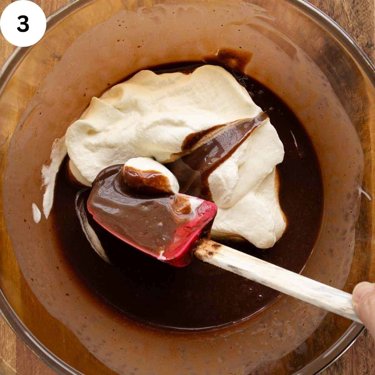 Folding chocolate mixture with whipped cream.