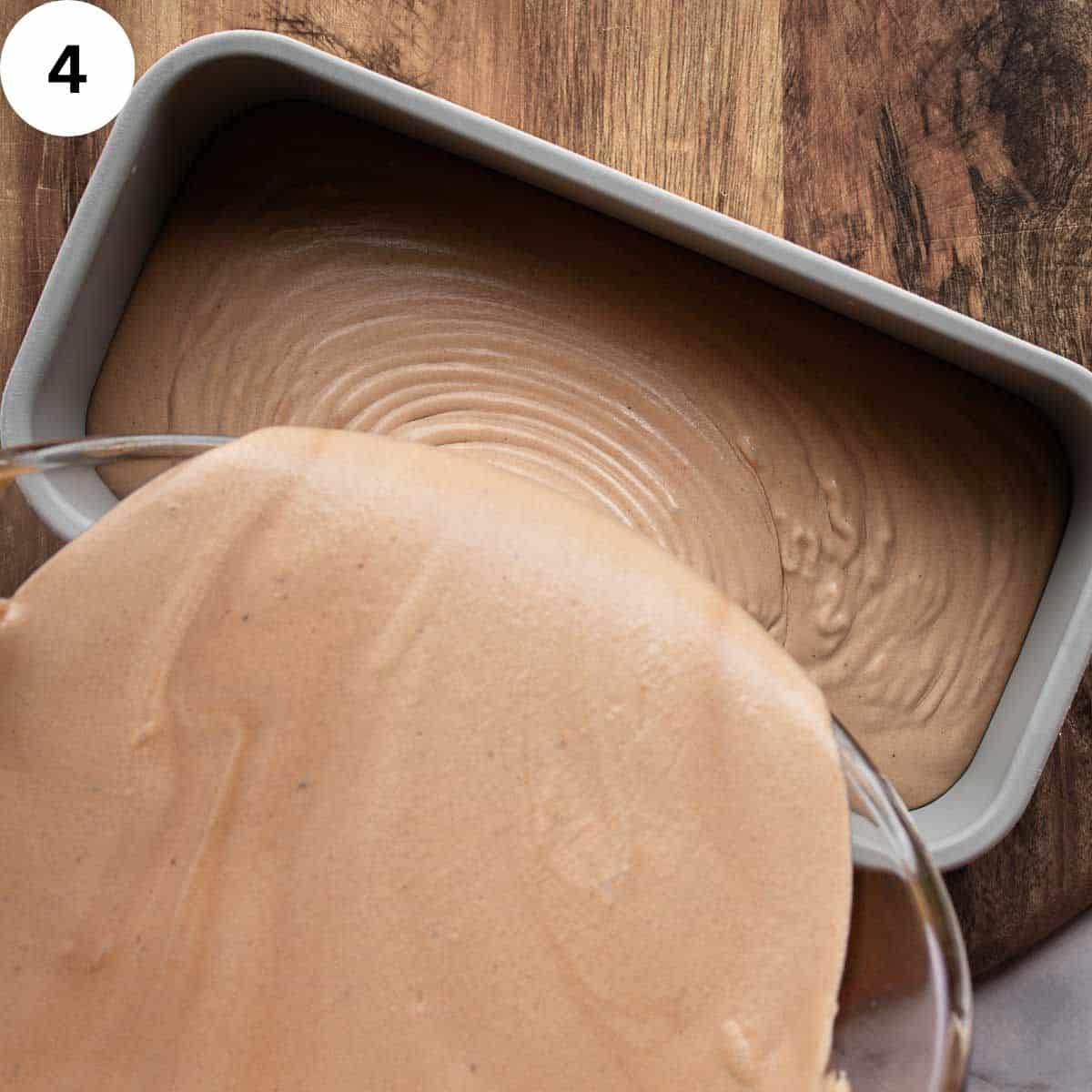 Pouring chocolate ice cream mixture into a loaf pan.