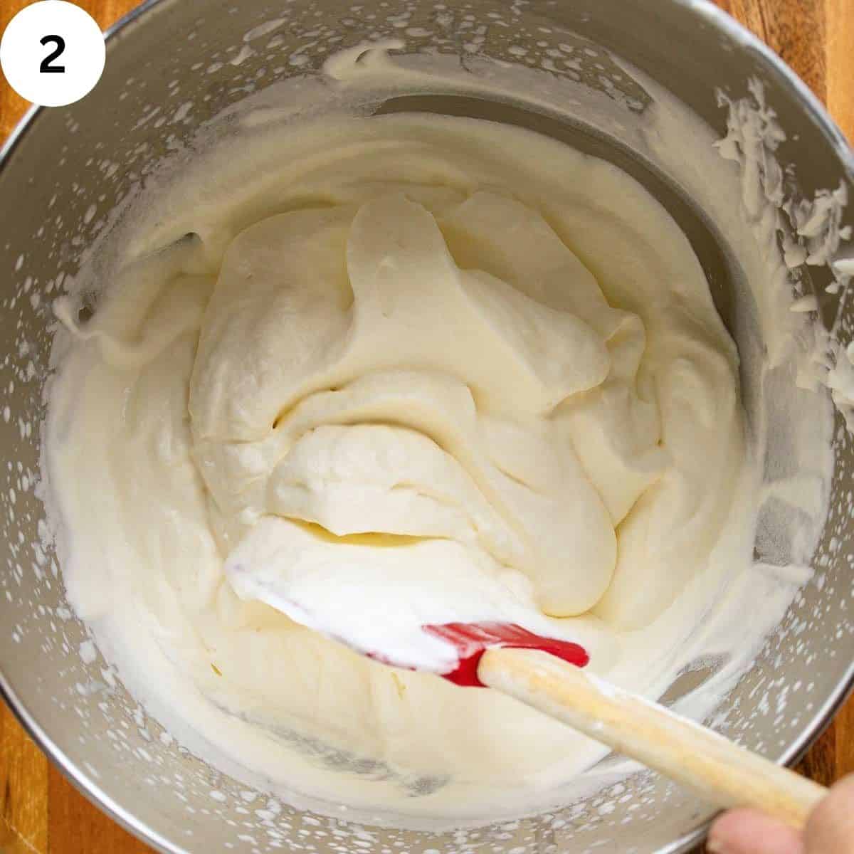 Whipped cream in a stainless steel bowl.