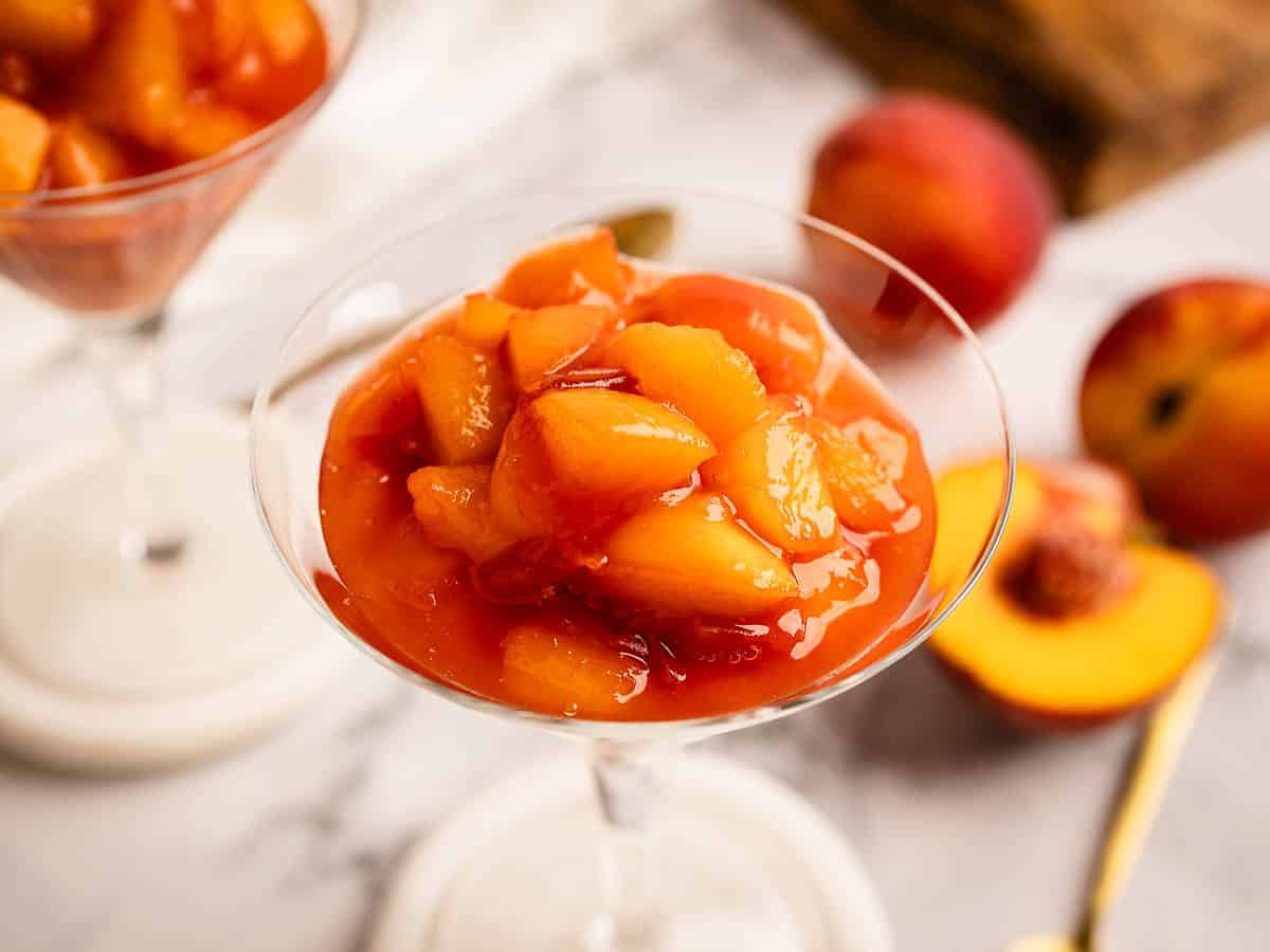 Close up of chunky peach sauce in a martini glass.
