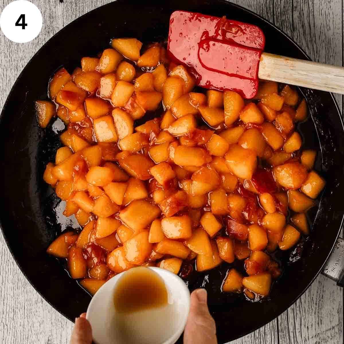 Adding vanilla extract to a skillet of chopped, cooked peaches.